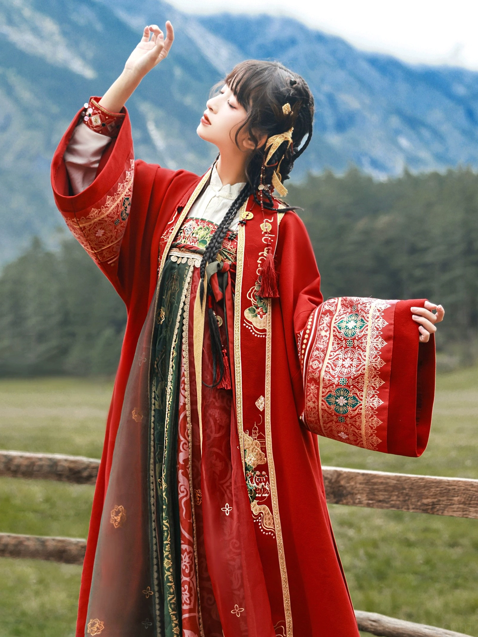 Close three quarter view of red embroidered cuff on modern Dunhuang Tang style Hanfu coat with layered green and red dress
