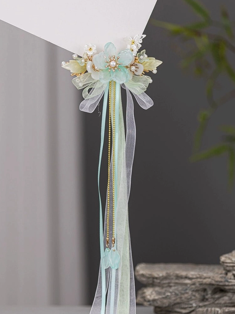 Top view of Snow Lotus Chinese Hanfu tassel hairpin showing mint green water drop pendants floral ornaments and elegant hanging tassels