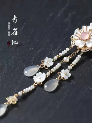 Close-up of Snow Lyrics Chinese hair stick tassels with pearl-style beads, small flower charms, and teardrop agate pendants