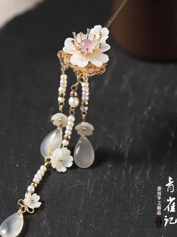 Side view of white flower Chinese hair stick with layered tassel chains and pale teardrop agate accessory details