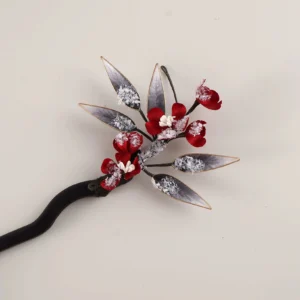 Snow plum blossom Chinese hair stick with red fabric flowers, snow-dusted leaves, and dark wooden shaft shown on a light grey background