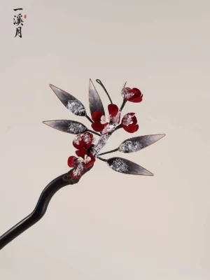 Three-quarter view of a traditional Hanfu Chinese hair stick decorated with red plum blossoms, white buds, and frosted botanical leaves