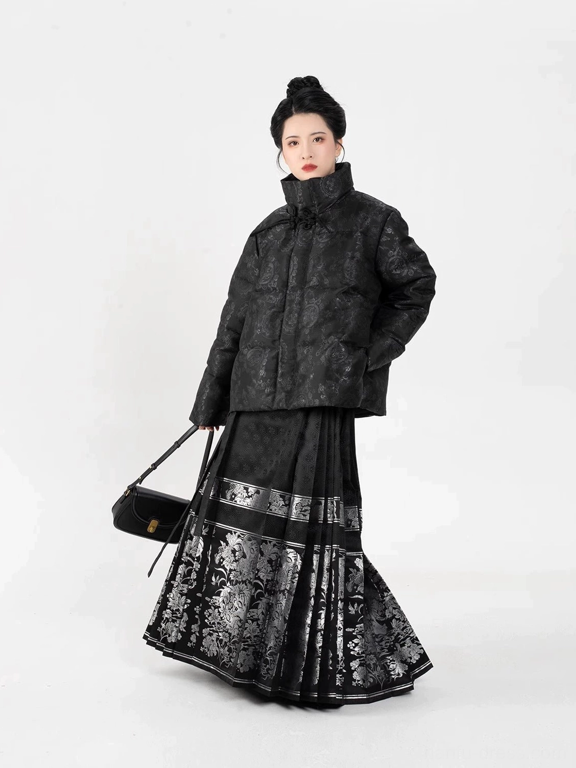 Three-quarter side view of a solid black modern Hanfu women's puffer coat with subtle tonal jacquard texture and relaxed cropped silhouette
