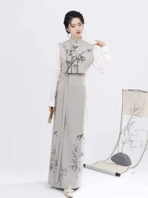 Female model wearing a complete Song Dynasty modern Hanfu set with ink bamboo print vest and wrap skirt while holding a traditional wooden folding fan