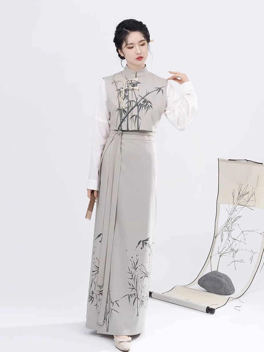 Female model wearing a complete Song Dynasty modern Hanfu set with ink bamboo print vest and wrap skirt while holding a traditional wooden folding fan
