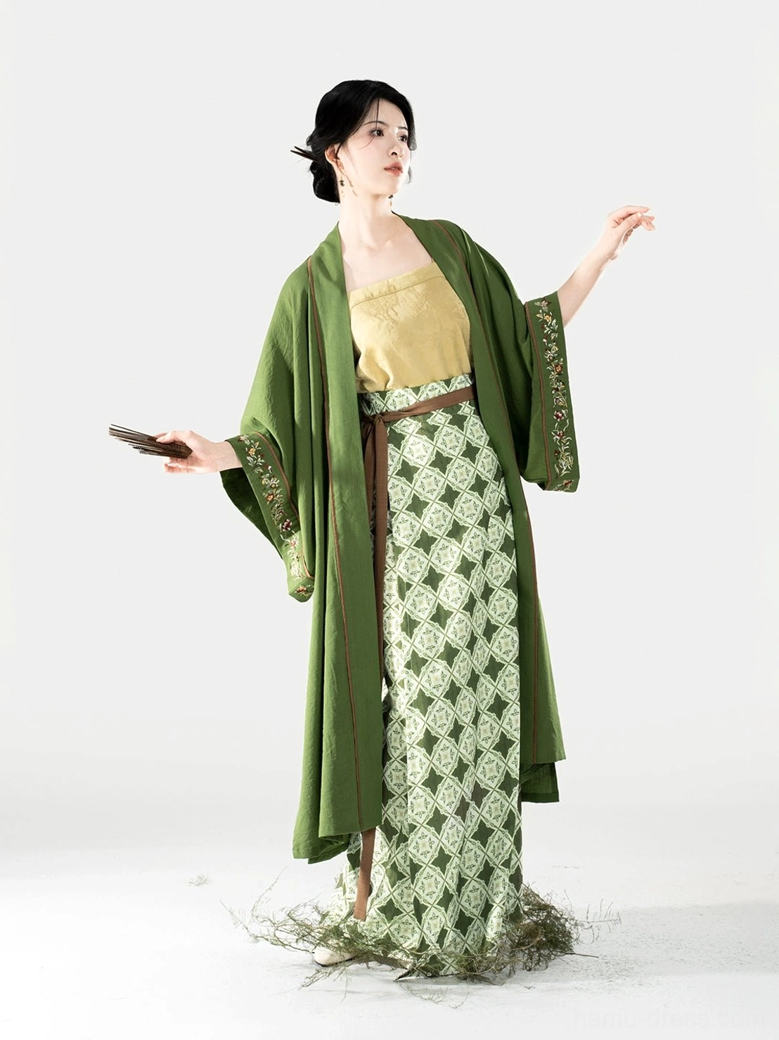 Song Dynasty hanfu outfit featuring an open moss green beizi brown trim pale yellow camisole and patterned wrap skirt shown from the left side