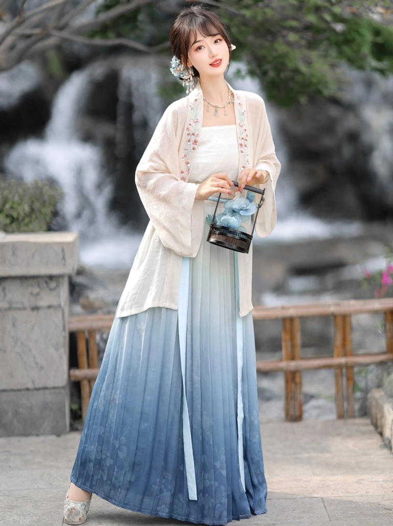 Front view of elegant Song Dynasty Hanfu with cream outer coat and blue gradient pleated skirt styled with a vintage black handheld lantern in a classical courtyard