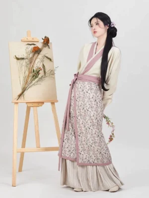 Song Dynasty Hanfu inner top and spiral skirt shown from the side with cross collar, pink waist sash, floral panel, and pleated hem