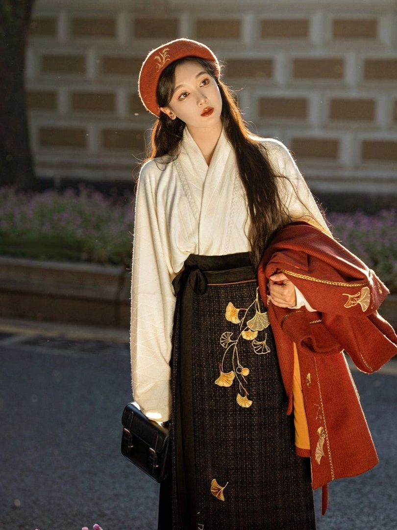 Off-white cross-collar winged sleeve Hanfu top with black plaid wrap skirt and golden ginkgo embroidery detail