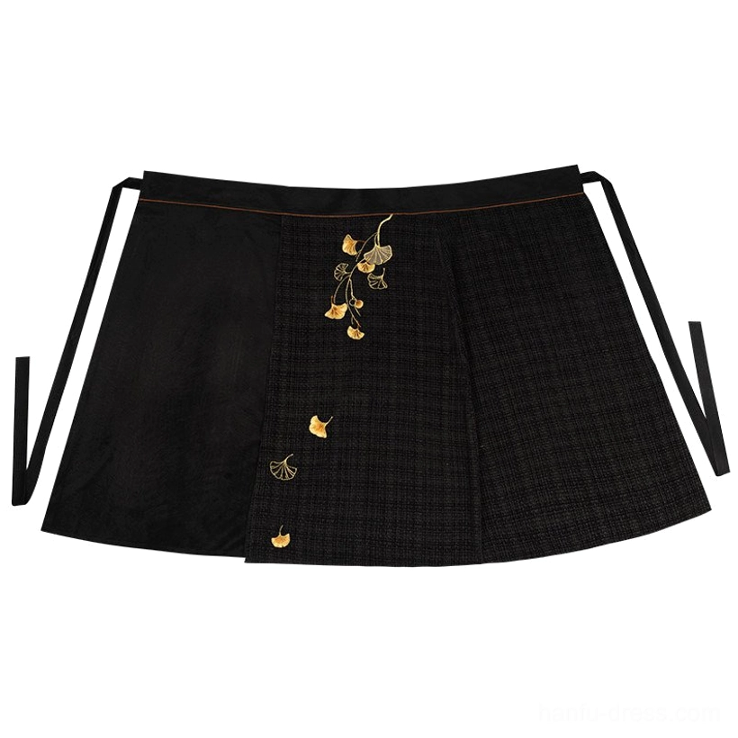 Flat lay of dark plaid Hanfu wrap skirt featuring golden ginkgo leaf embroidery and side waist tie straps