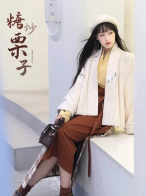 Modern Song Dynasty Hanfu Fried Chestnuts outfit shown from a seated three quarter angle with cream outerwear, mustard cross collar top, brown layers, and plaid wrap skirt