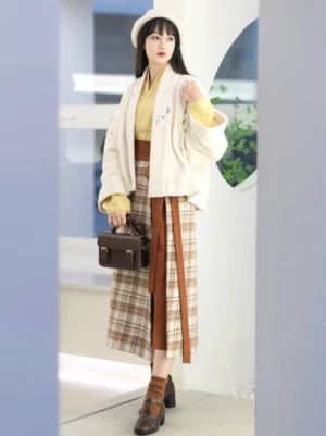 Full front view of modern Song Dynasty Hanfu Fried Chestnuts styling with cream coat, mustard top, brown plaid wrap skirt, handbag, and block heel shoes