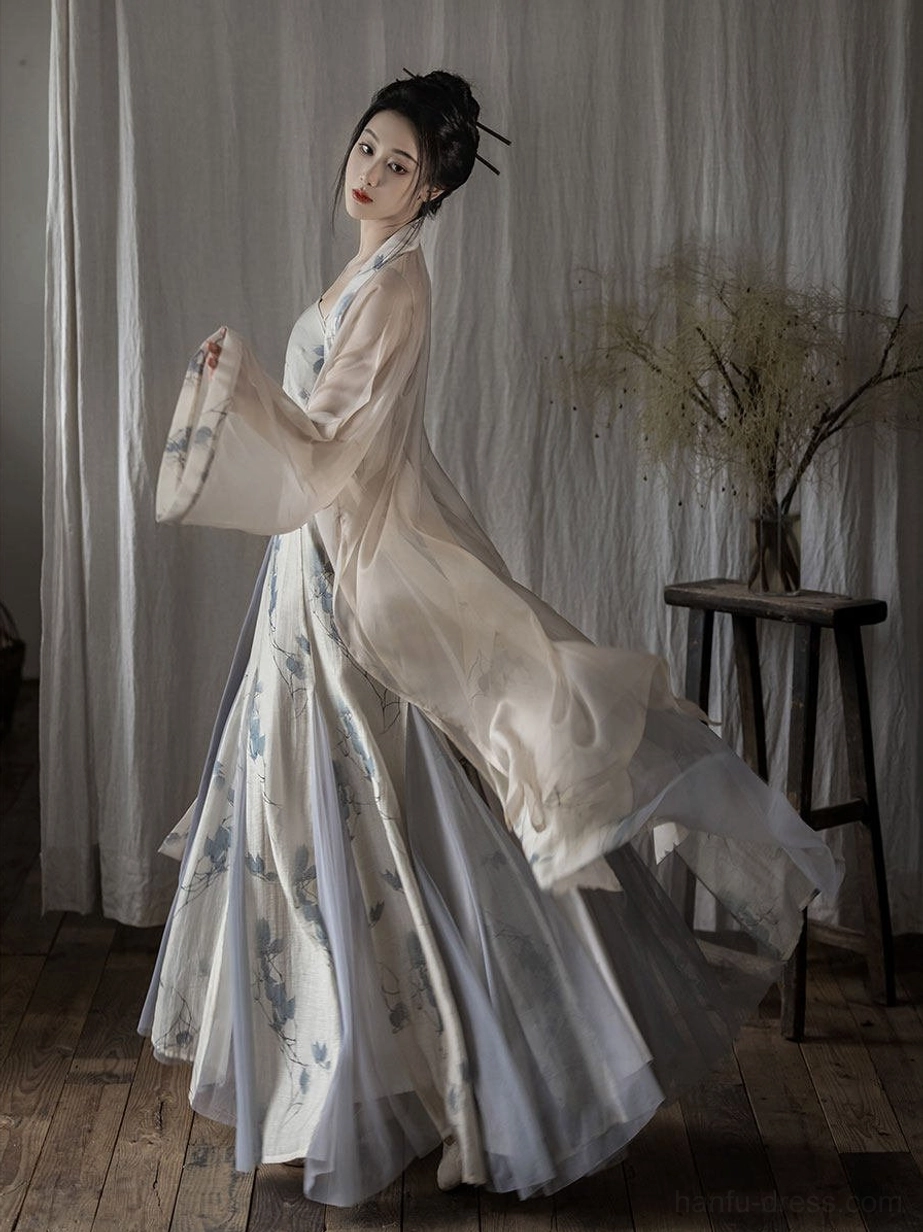 Rear three-quarter view of ivory Song Dynasty Hanfu with sweeping long outer jacket and blue floral printed skirt