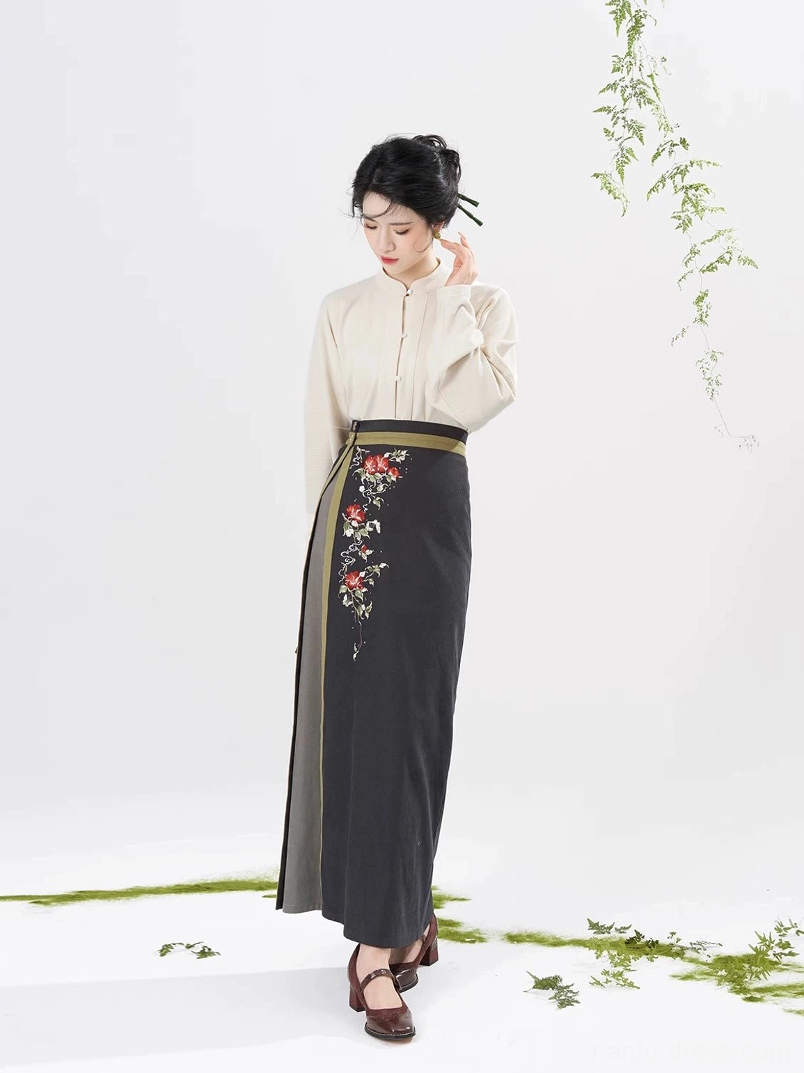 Side full body view of ivory stand collar hanfu top and charcoal grey embroidered wrap spiral skirt
