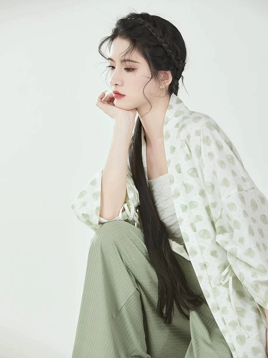 Close-up of layered Song Dynasty Hanfu outfit showing ivory camisole beneath leaf-print winged sleeve outer top