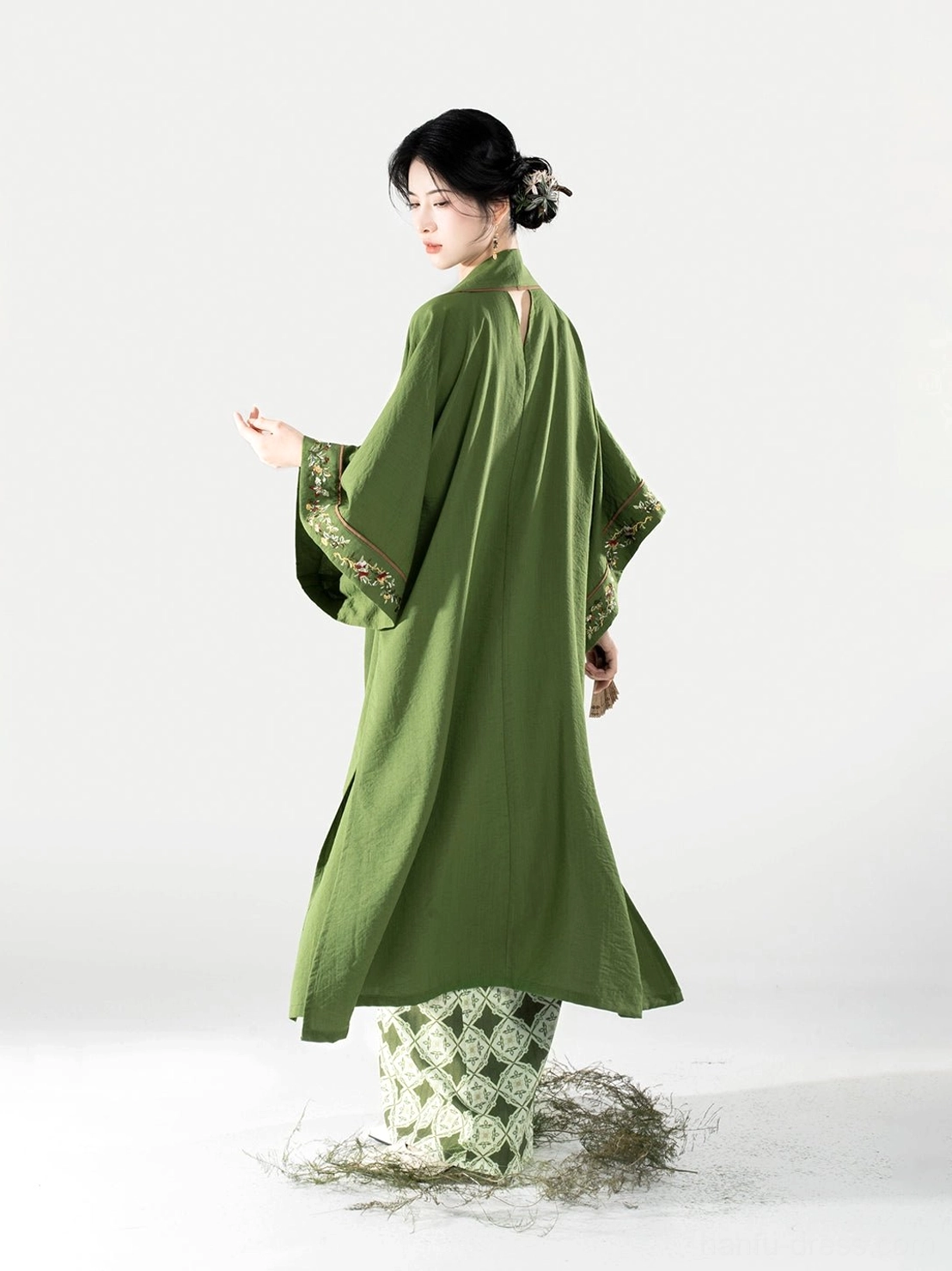 Back view of a Song Dynasty hanfu outfit showing the open drape of the moss green beizi and geometric spiral skirt hem