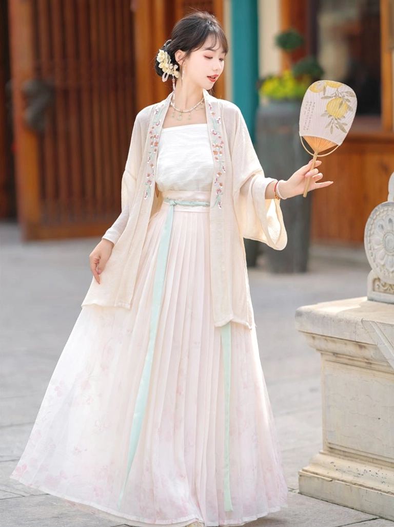 Side three-quarter view of Song Dynasty Hanfu featuring a cream beizi coat, pink ombre pleated skirt, mint green waist sash, and round patterned hand fan