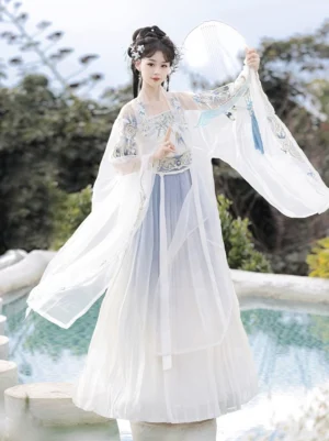 Three-quarter front view of a blue and white Song Dynasty hanfu outfit with sheer white outer beizi coat, blue embroidery, flowing wide sleeves, traditional hair ornaments, and round silk fan in a garden setting