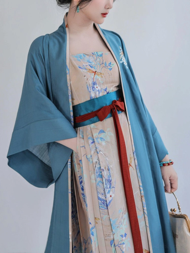 Close-up view of Song Dynasty Hanfu waist styling showing layered teal and red belts, flowing sashes, floral Beizi embroidery, and soft textured fabric with vintage handbag