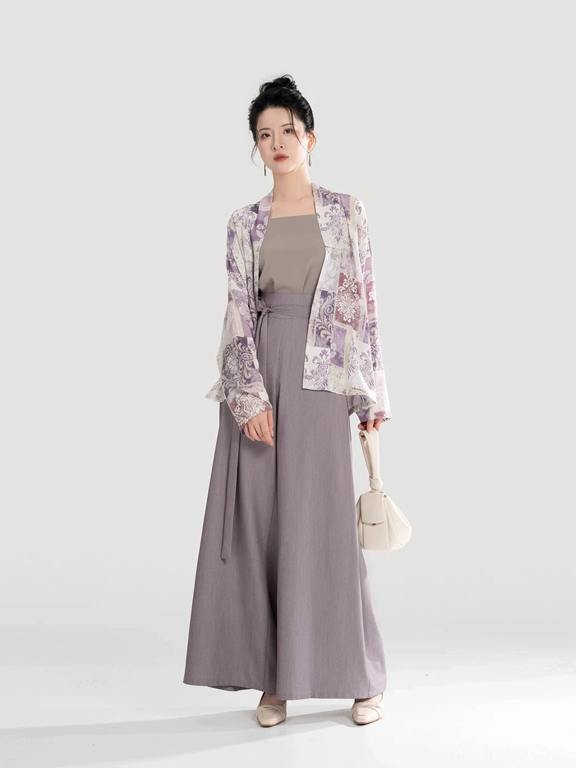 Side-front view of a Song Dynasty-inspired Hanfu clothing set with flowing winged sleeves wide-leg trousers and beige handbag