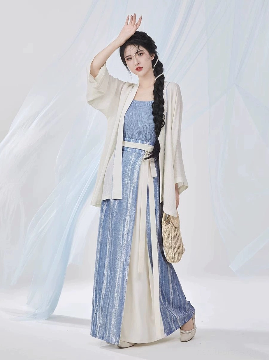 Three-quarter front view of a woman modeling a modern Song Dynasty Hanfu outfit in coordinated sky blue and ivory with a flowing long-sleeve shirt and pleated skirt