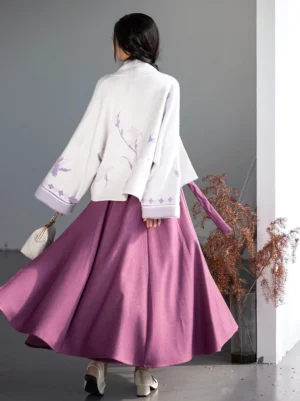 Back view of a Song Dynasty-inspired modern hanfu outfit with an embroidered ivory jacket and flowing deep purple pleated wrap skirt