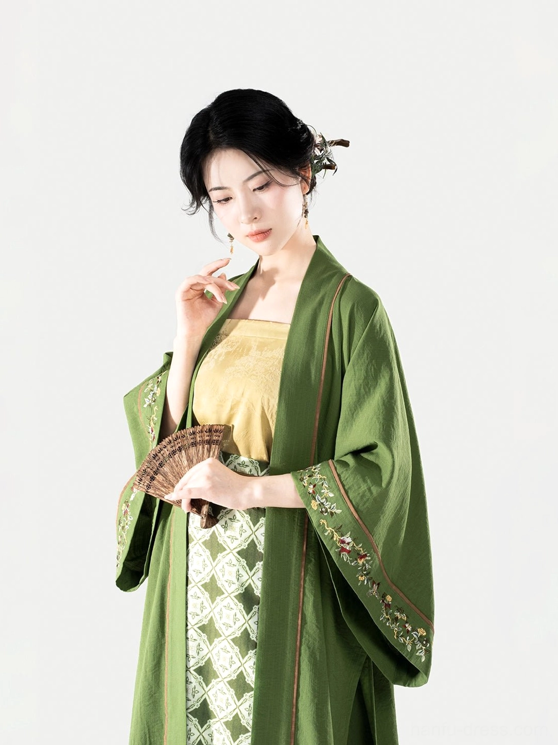 Close-up front view of a Song Dynasty modern hanfu set with green Changgan Temple jacket yellow camisole and patterned wrap skirt