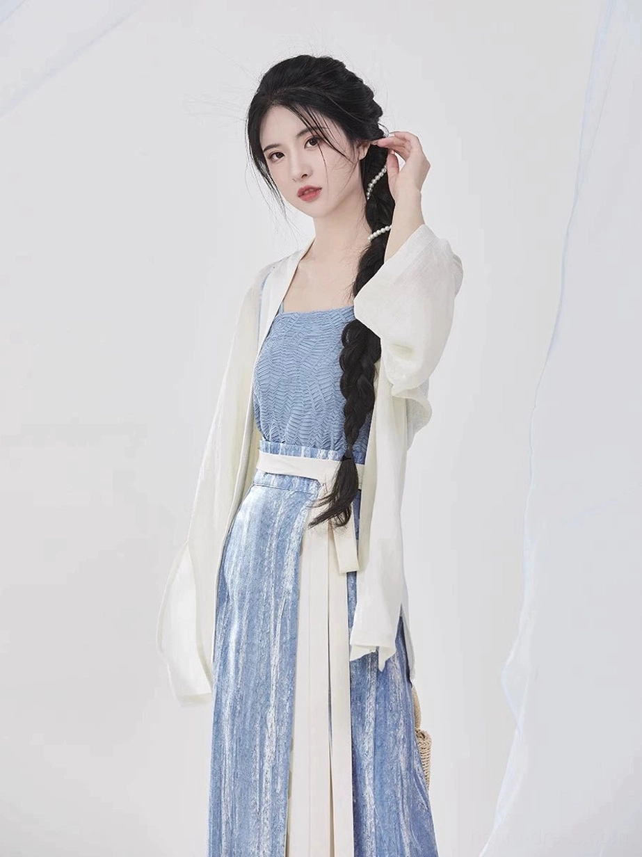 Close-up view of a sky-blue Hanfu camisole with square neckline styled beneath an ivory Song Dynasty shirt and finished with a tailored white waist sash
