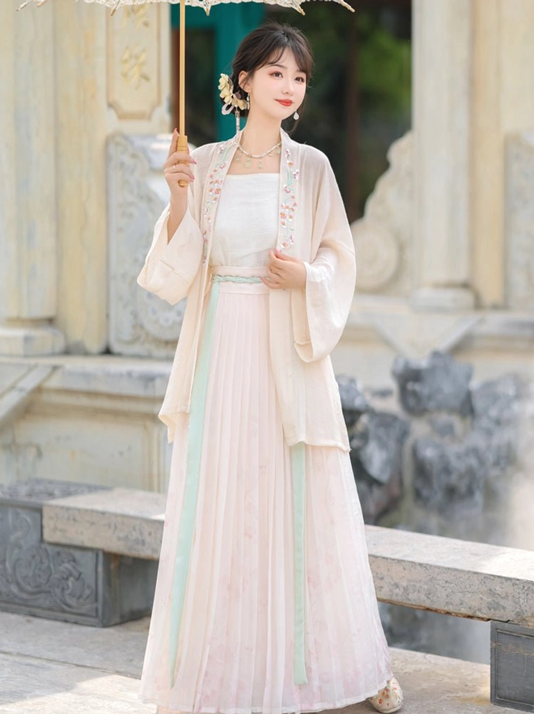 Front three-quarter view of pink Song Dynasty Qiyao Ruqun Hanfu with cream embroidered beizi, mint green sash, pink gradient skirt, and traditional oiled paper umbrella