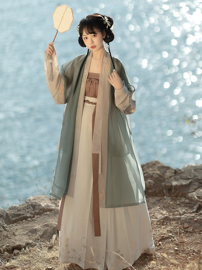 Front view of Song Dynasty Qiyao Ruqun Hanfu with sheer sage green outer coat, earthy brown camisole and floral hem ivory maxi skirt