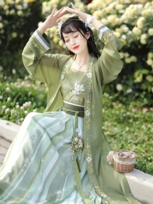 Three-quarter seated view of Song Dynasty style qiyao ruqun hanfu with sheer green inner blouse, embroidered camisole, golden sleeve trim, waistband details, and striped wrap skirt