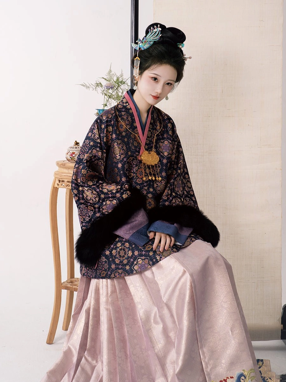 Seated model wearing elegant Song Dynasty winter Hanfu mamianqun outfit with fox fur trimmed brocade coat and traditional hair accessories