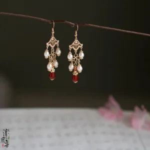 Song of Fire vintage Chinese drop earrings with gold fan-shaped filigree, white pearl pendants, and red teardrop ornaments displayed in an antique Hanfu jewelry setting
