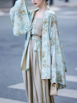 Side view of a modern Song-style Hanfu floral cardigan with loose wide sleeves and flowing fabric worn as part of a contemporary commuting outfit
