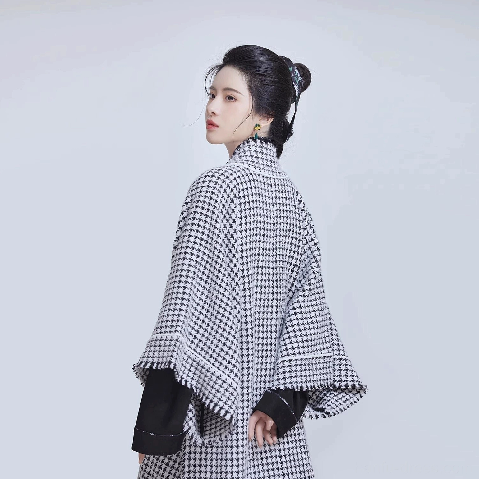 Rear three-quarter view showing the flowing back fit and wide sleeves of a Song-style houndstooth beizi outer Hanfu jacket