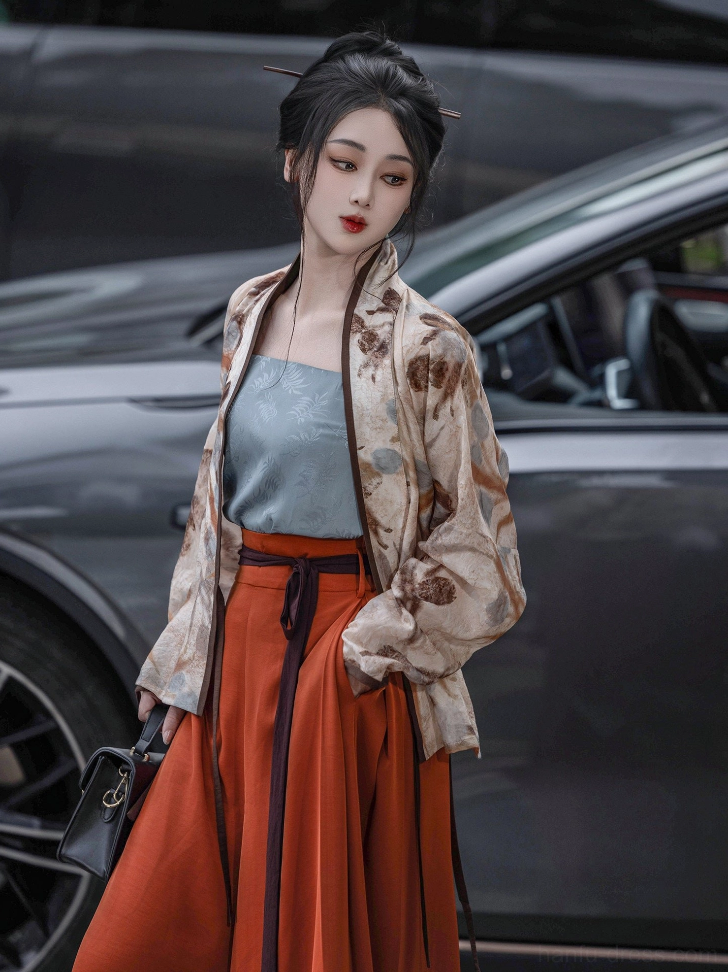 Modern Song style Hanfu cropped vest with withered flowers print paired with terracotta skirt beside a car