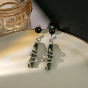 Spirit Snake green drop earrings with rhinestone silver snake pendant displayed on a yellow ceramic tray for Hanfu and Chinese style outfits