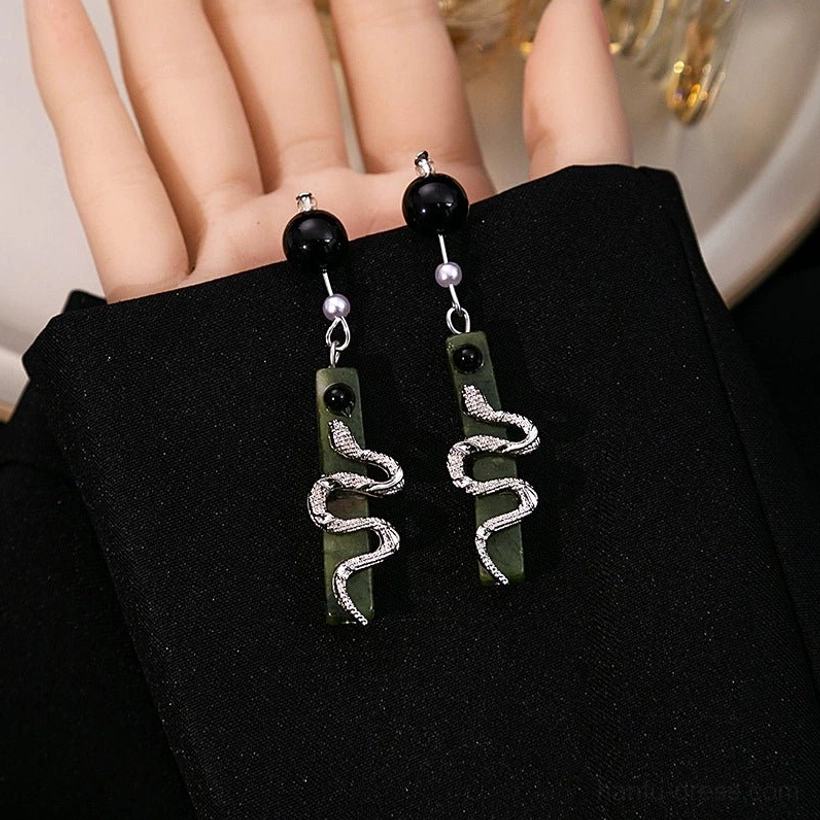 Close-up of Spirit Snake Hanfu earrings showing silver ear stud, black bead, pearl accent, and rhinestone snake green pendant