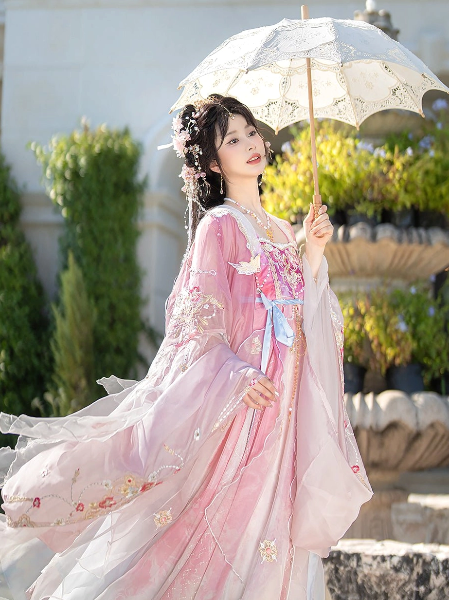 Dynamic outdoor view of Spring Banquet Tang Dynasty Hanfu complete set with wind-blown sheer sleeves, floral embroidery, beaded bodice ornaments, and long gradient skirt