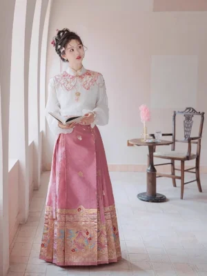 Three-quarter front view of Spring Melodies Ming style Hanfu outfit with embroidered dusty rose mamianqun horse face skirt and white lantern sleeve blouse