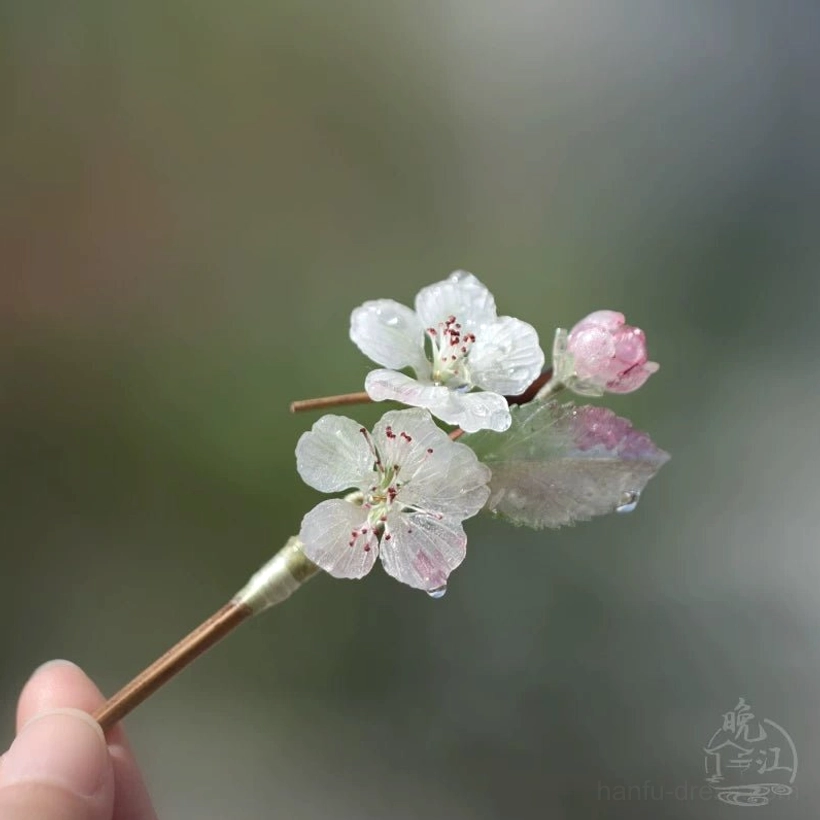 Handheld small pear blossom Chinese hair stick with pink flower buds green leaves and smooth wooden style stem