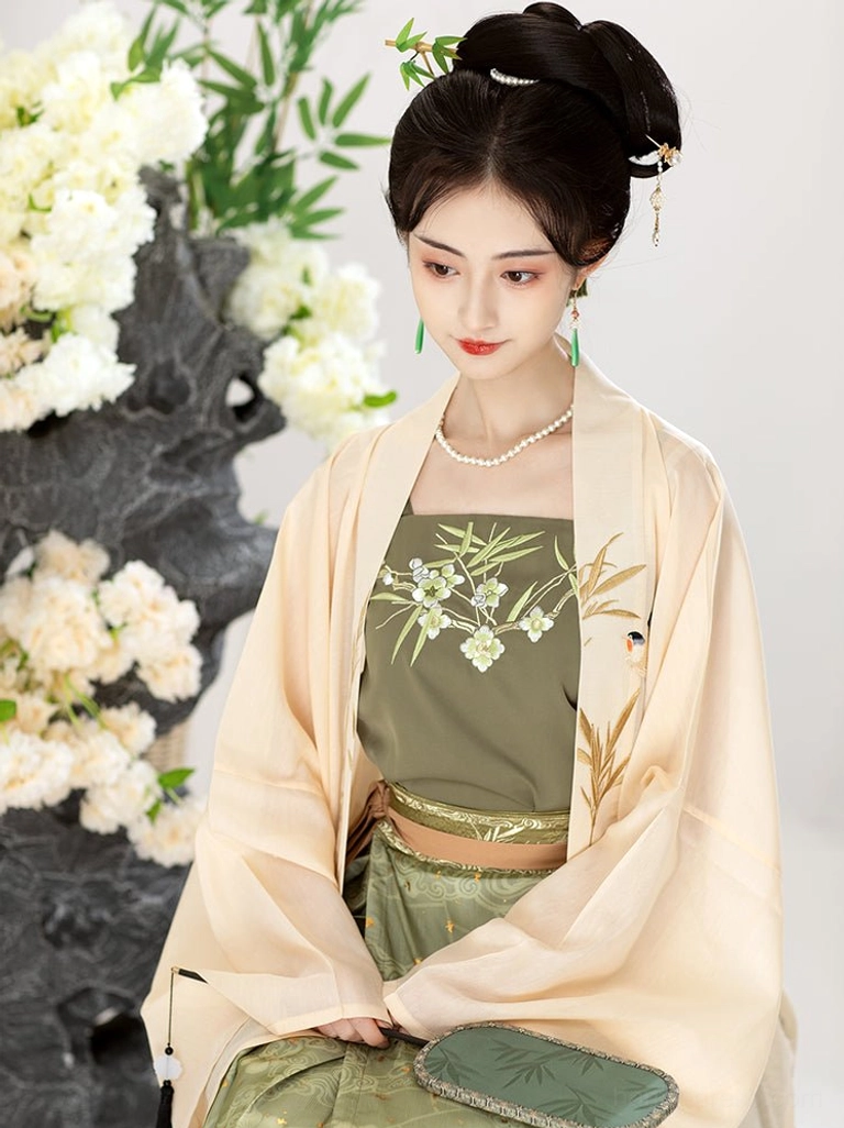 Close-up view of Song Dynasty Hanfu embroidery featuring bamboo, flowers and bird motifs on the moss green top beneath a cream Beizi coat