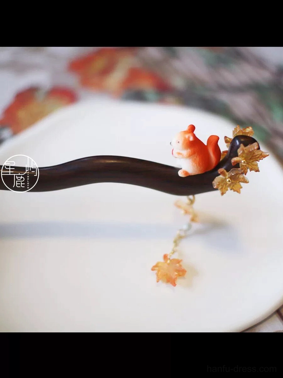 Close-up of squirrel and maple leaf Chinese hair stick with orange squirrel ornament, leaf charms and beaded autumn tassel