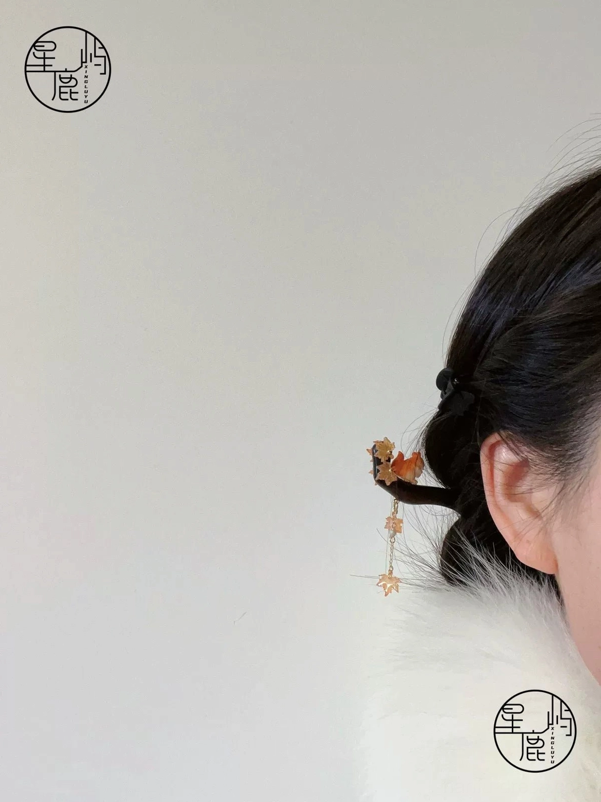 Squirrel maple leaf Chinese hair stick worn in a traditional updo with elegant tassel hanging beside the hairstyle