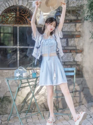 Modern Hanfu summer outfit in baby blue with cropped ruffled camisole, high-waisted wide-leg shorts, and lace-trimmed sheer blouse worn with a straw hat
