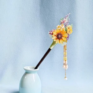 Sunflower tassel Chinese hair stick displayed in a light blue porcelain vase with dark brown pin, floral ornament, pearl beads and gold-tone tassels
