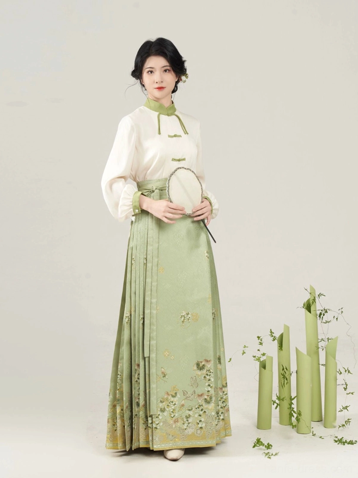 Full body front view of ivory Chinese style blouse and sage green embroidered mamian skirt Hanfu outfit with silk fan