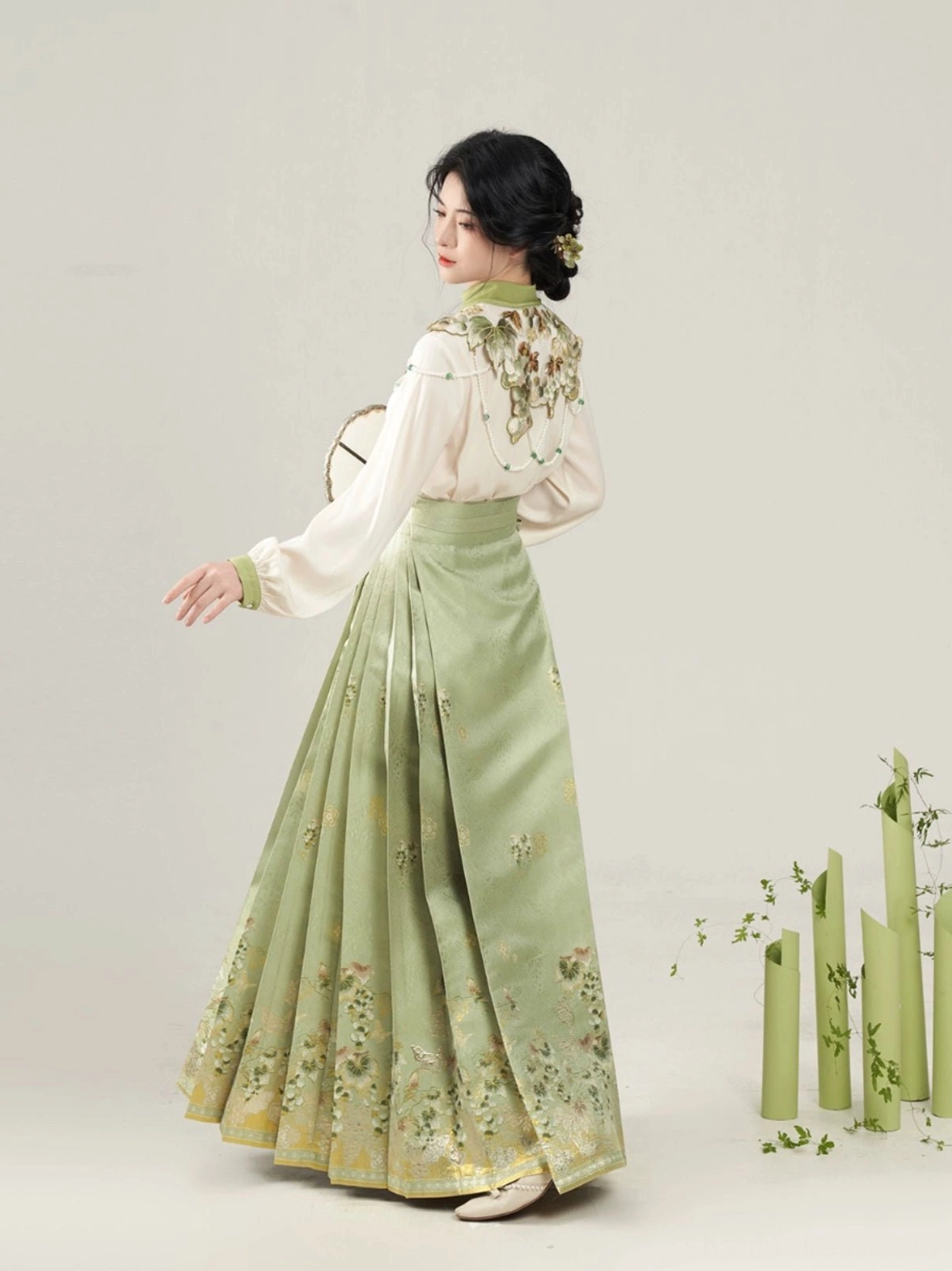 Side rear view of Ming Dynasty inspired Hanfu set showing ivory lantern sleeve blouse and flowing green mamian skirt