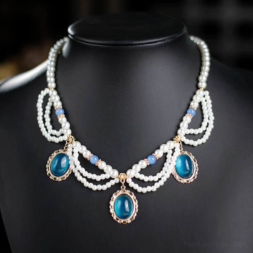 Full front view of a symmetrical vintage Chinese pearl necklace with multiple layered chains, light blue bead accents, and three deep blue oval pendants set in smooth gold-tone frames