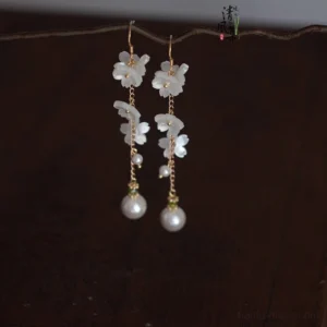 Symmetrical white flower Chinese drop earrings with gold chains and large round pearl pendants for Hanfu and Qipao styling